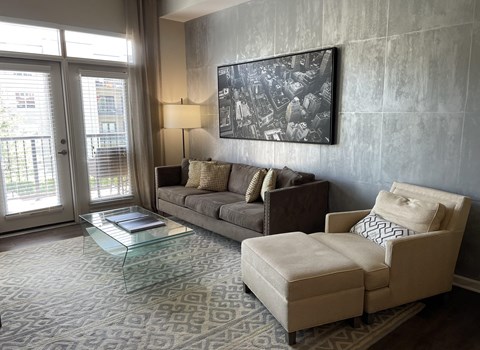 a living room with a couch and a chair and a glass table